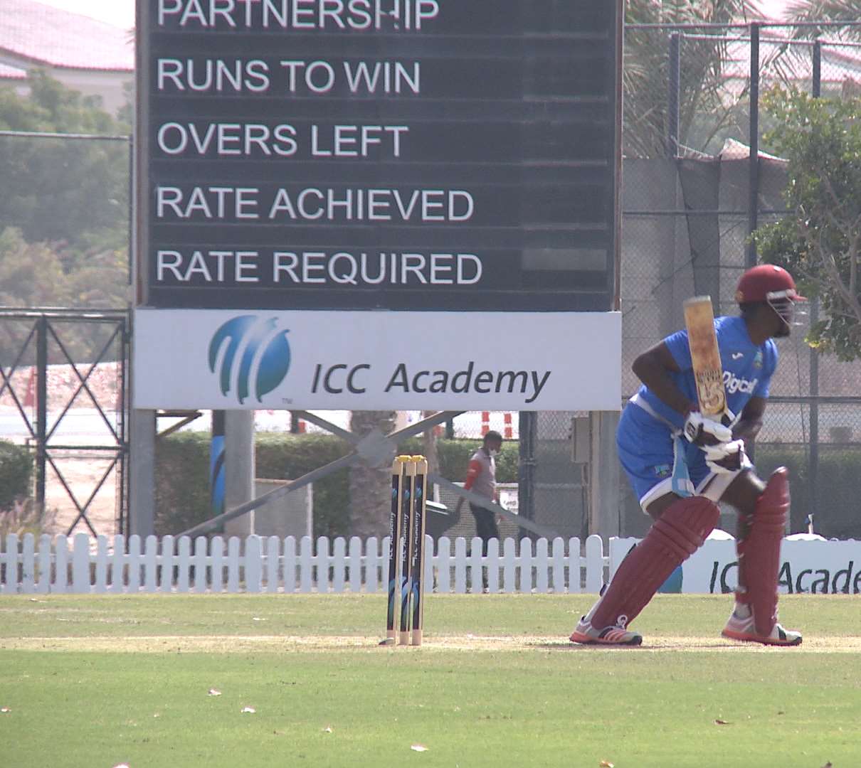 A batsman in front of the ICC Academy scoreboard