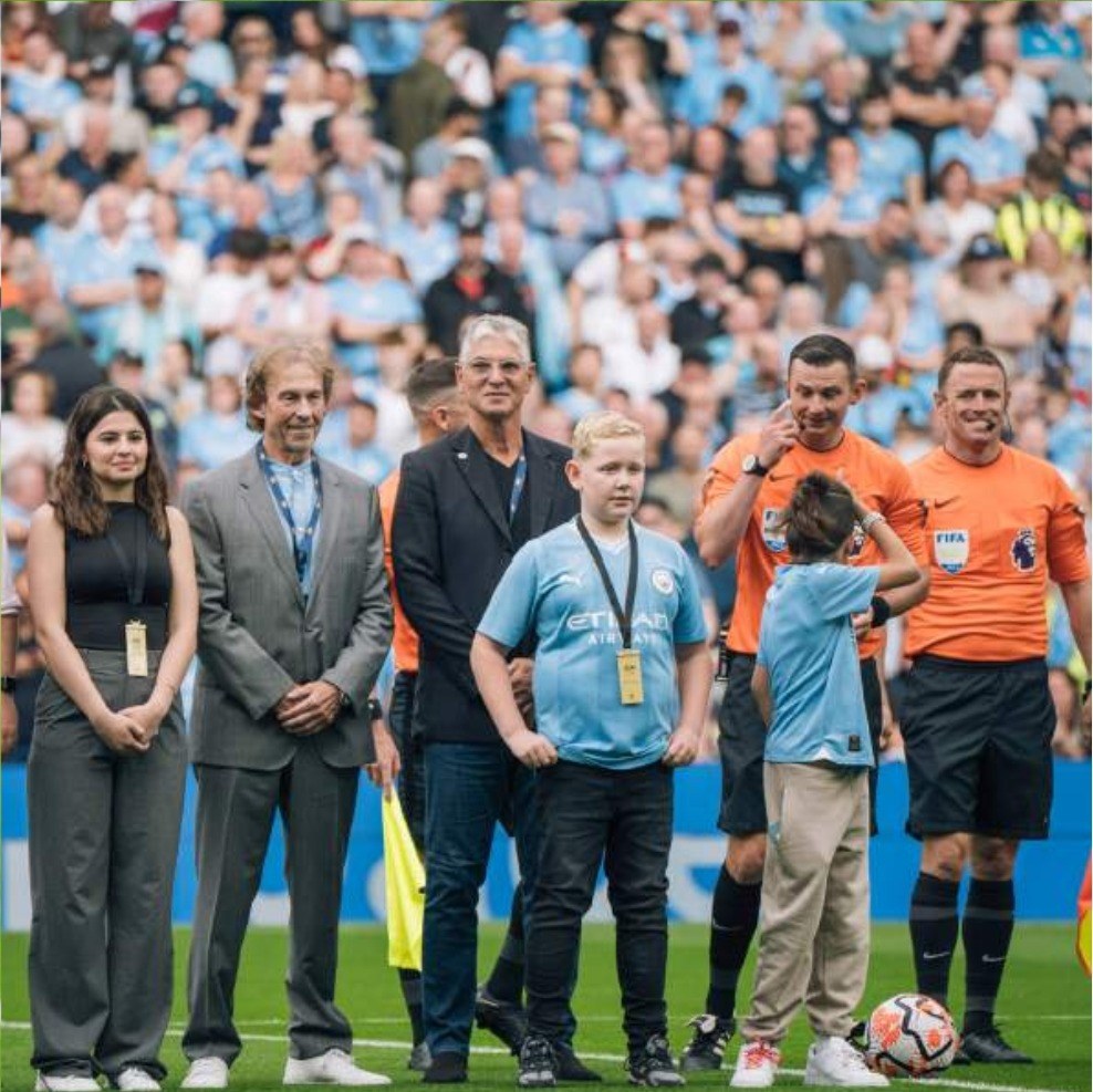 Guests and mascots on the pitch with the match officials before kick off