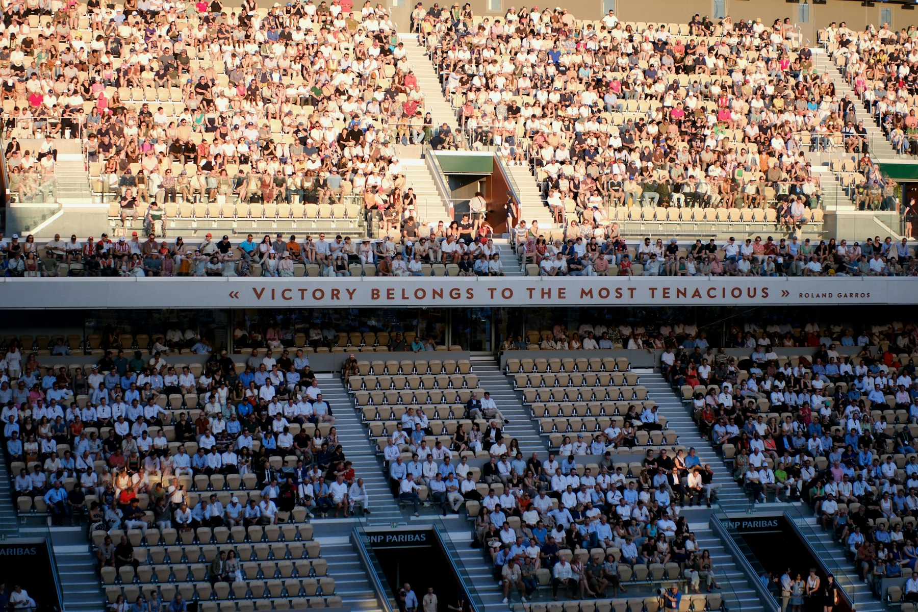 A full grandstand of spectators at a tennis stadium