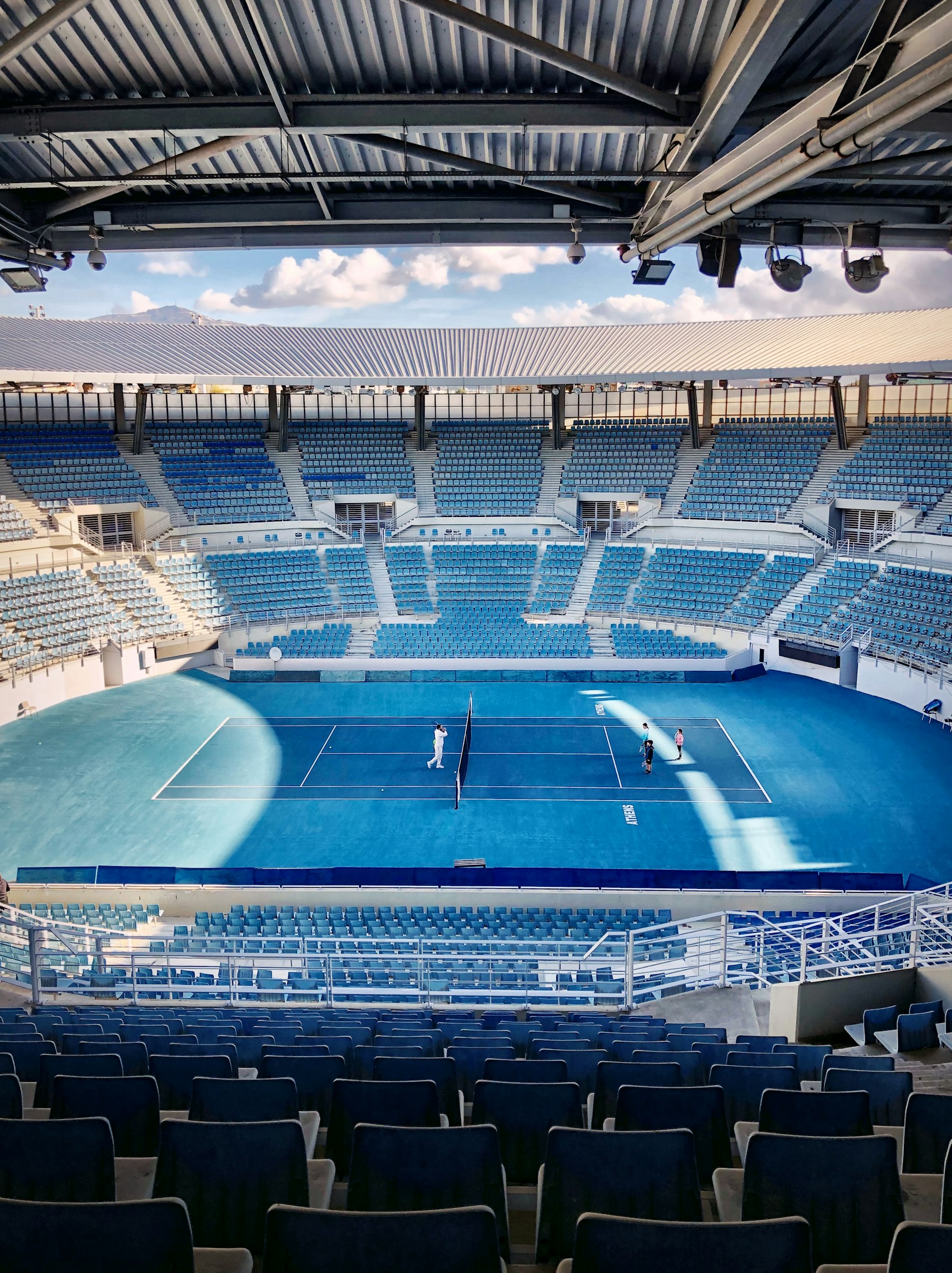 A tennis stadium with rows of blue seats