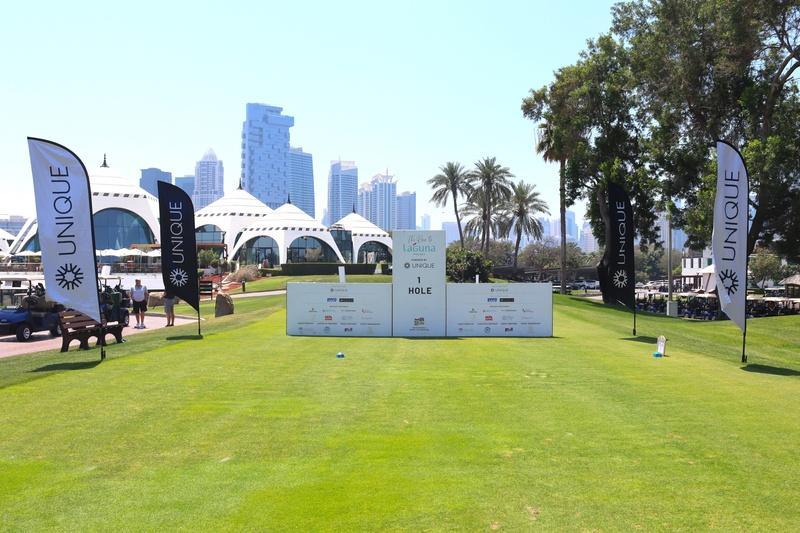 A branded tee box with the Dubai skyline behind